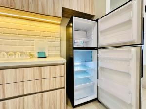 un frigorifero con porta aperta in cucina di Premium Comfort Rooftop View bayan lepas airport 9pax a Bayan Lepas