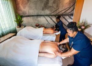 a group of women performing a massage on a bed at Grootbos Private Nature Reserve in Gansbaai