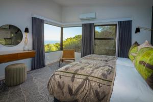 a bedroom with a large bed and a large window at Grootbos Private Nature Reserve in Gansbaai +37 photos