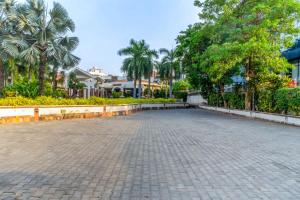 una strada vuota in un parco con palme di Prakruti Resort a Vadodara