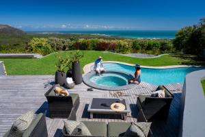 two people sitting around a pool in a backyard at Grootbos Private Nature Reserve in Gansbaai
