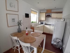 a kitchen with a table with chairs and a white refrigerator at Domek Łagów Lubuski in Łagów +4 photos
