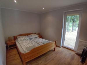 a bedroom with a bed and a large window at Domek Łagów Lubuski in Łagów