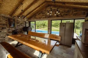 a dining room with a wooden table and some windows at Villa Aurea in Neum