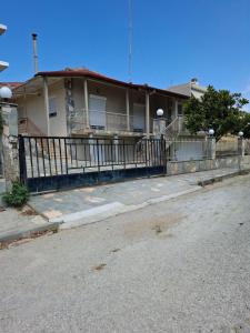 a house with a fence in front of a street at Titi's home in Ofrínion