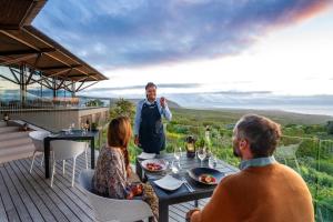 a man and two women sitting at a table on a deck at Grootbos Private Nature Reserve in Gansbaai