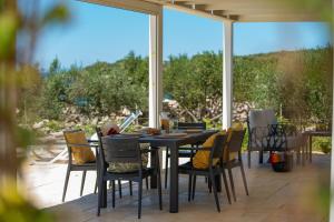a table and chairs on a patio with a large window at Terra Park Phalaris in Novalja