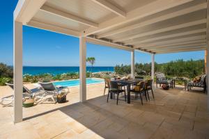 a patio with a table and chairs and the ocean at Terra Park Phalaris in Novalja