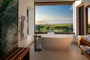 a bath tub in a bathroom with a large window at Grootbos Private Nature Reserve in Gansbaai