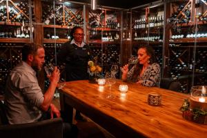 a group of people sitting around a wooden table in a wine cellar at Grootbos Private Nature Reserve in Gansbaai