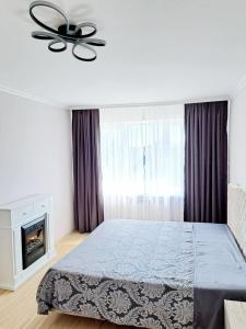 a bedroom with a bed and a chandelier at White Home & Garden in Klaipėda