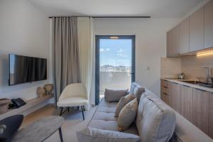 a living room with a couch and a kitchen at Sokio Attiki Hotel, BW Premier Collection in Athens