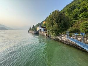 a large body of water with blue benches next to a hill at Villa Planca by Gottschalk in Fiumelatte
