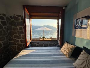 a room with a window looking out at the ocean at Villa Planca by Gottschalk in Fiumelatte