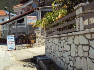 a building with a stone wall next to a street at Stamatia Rooms in Parga