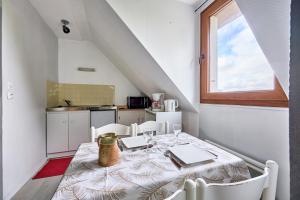 a dining room with a table and chairs and a window at Le Nid Marin - A 400m de la plage in Saint-Aubin-sur-Mer