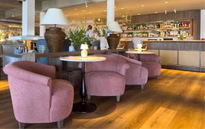 a restaurant with pink chairs and a bar at Havna Hotel & Sjøbad in Tjøme