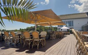 a deck with chairs and tables and umbrellas at Havna Hotel & Sjøbad in Tjøme