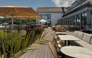 an outdoor patio with tables and chairs and umbrellas at Havna Hotel & Sjøbad in Tjøme