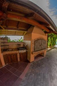 an outdoor kitchen with a roof with a sink at Zidanica Krošelj in Raka +28 photos