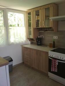 a kitchen with wooden cabinets and a stove at A Fogadó Vendégház in Sárospatak
