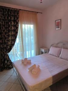 une chambre avec un lit avec deux serviettes dessus dans l'établissement Fridas Home Apartment, à Alexandroúpolis