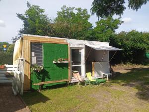 a green trailer with two chairs in a yard at Zielony Port numer 2 in Władysławowo