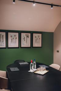 Una mesa negra con botellas y vasos sobre una pared verde. en Maison Orphée, en París 77 fotos más