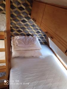 a bed with a pillow in a small room at Zielony Port numer 2 in Władysławowo