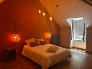 a bedroom with a bed and a window and lights at La Maison du Marinier in Crouzilles