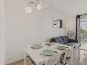 comedor blanco con mesa y sofá en Face au port - 400m plage - Appart pour 2, en Arzon