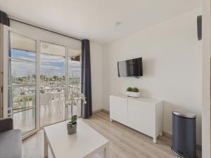 una sala de estar blanca con vistas a la ciudad en Face au port - 400m plage - Appart pour 2, en Arzon