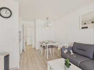 una sala de estar con un sofá y una mesa en Face au port - 400m plage - Appart pour 2, en Arzon
