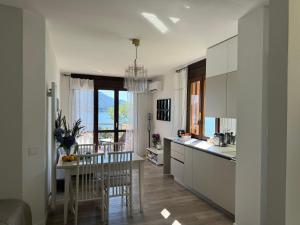 a kitchen with white cabinets and a table and chairs at Marta in Stresa