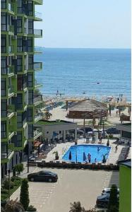 a building with a swimming pool next to a beach at WaterFront Apartment - Beach Pool & Spa Resort langa plaja in Mamaia Nord