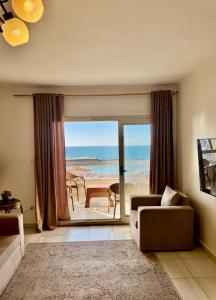 a living room with a couch and a view of the ocean at ALEX HOMES - Sporting Sidi Gaber Cozy Apartments with Direct Sea View - Families only in Alexandria