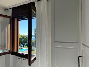a window in a room with a view of a pool at Marta in Stresa +13 photos