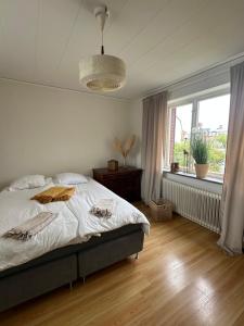 a bedroom with a bed and a large window at KvarteretSkatan! in Ystad