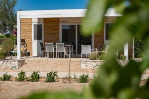a house with a table and chairs in front of it at Terra Park Phalaris in Novalja