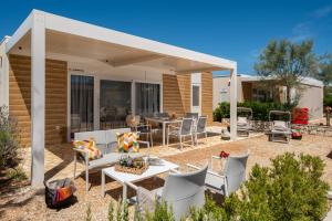 a patio with chairs and a table in front of a house at Terra Park Phalaris in Novalja