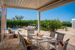 a patio with a table and chairs and a pool at Terra Park Phalaris in Novalja +37 photos