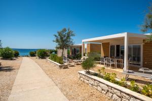 a house with a pathway next to the ocean at Terra Park Phalaris in Novalja