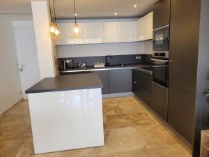 a kitchen with black and white cabinets and a counter at Splendide Vue Mer in Sainte-Maxime +3 photos