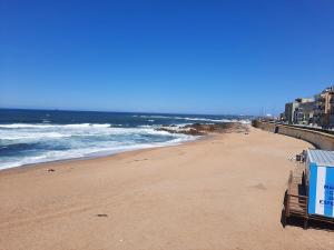 a beach with a sign on it and the ocean at Monsenhor52 in Porto