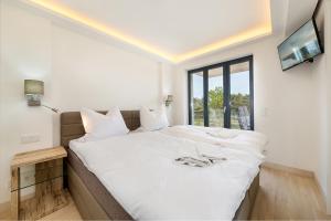 ビンツにあるHaus Avella Wohnung Nr. 29の大きな白いベッドと窓のある寝室