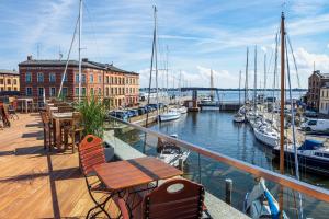 a balcony with a table and chairs next to a marina at Ferienhaus - Am Kütertor - alle Apartments mit Terrasse oder Balkon - in top Lage in Stralsund