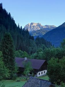 eine Scheune in einem Tal mit einem Berg im Hintergrund in der Unterkunft Le Chardon Bleu in Châtel