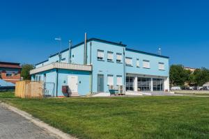 a blue building with a grass field in front of it at Rooms Casa Celeste sul Mare in Cesenatico