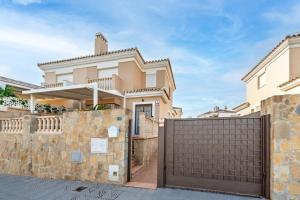 a house with a gate in front of it at Villa Patrizia un oasis de paz en Torre del Mar in Torre del Mar