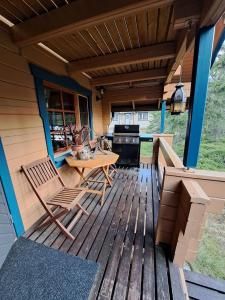 Una terraza de madera con una mesa y sillas. en Vanamo, en Syöte